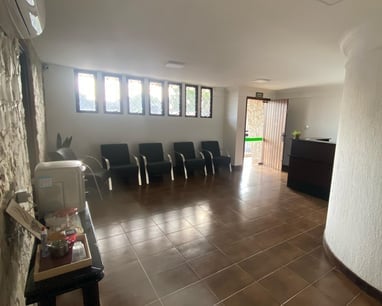 Sala de espera do consultório, com poltronas e boa iluminação natural